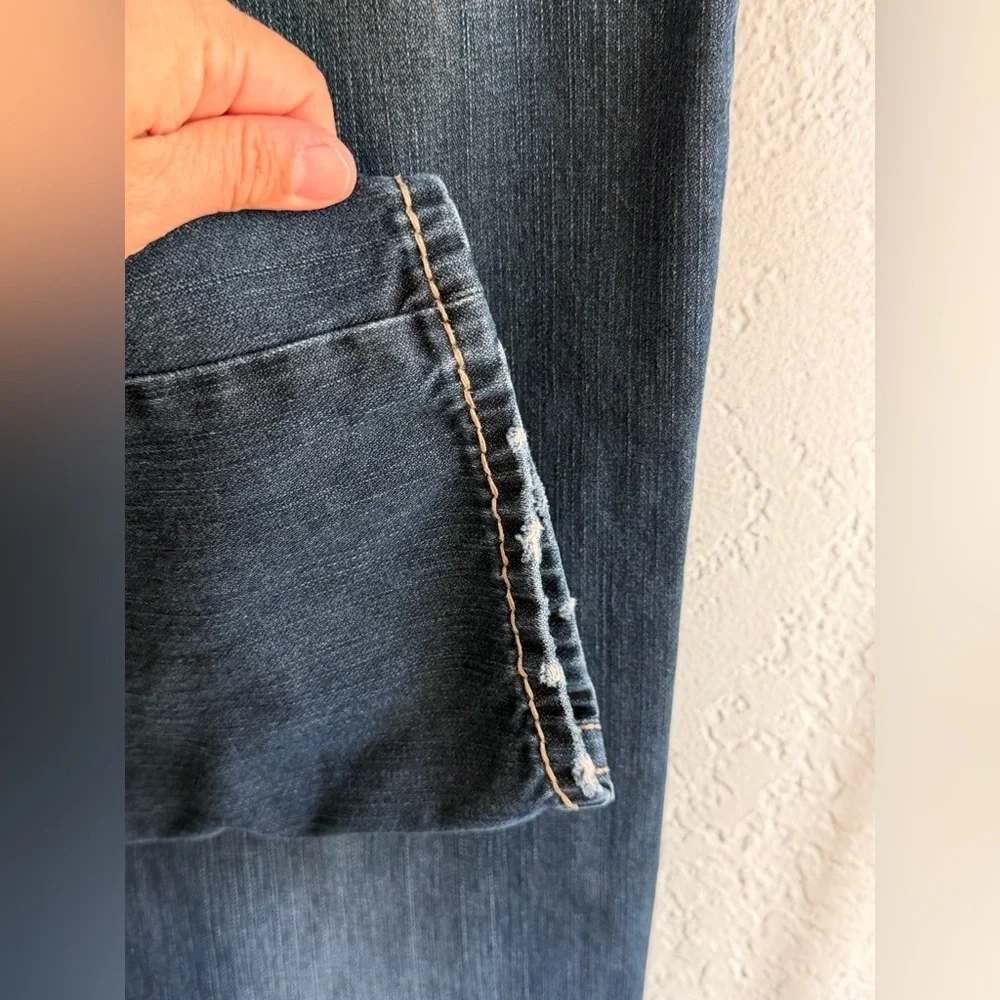 True Religion jeans feature a dark wash and bold signature stitching. Skinny